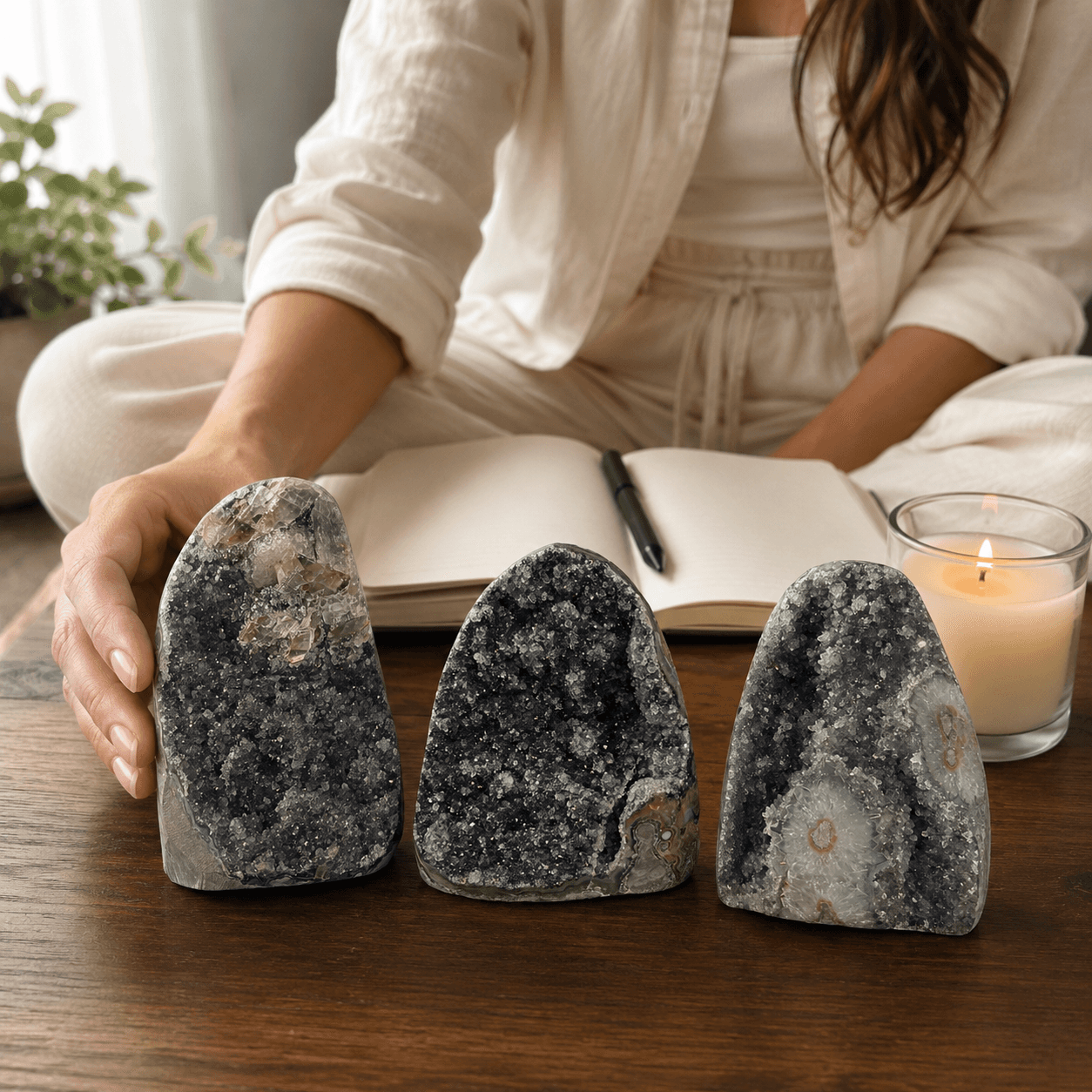 woman journaling with three black amethyst standing clusters