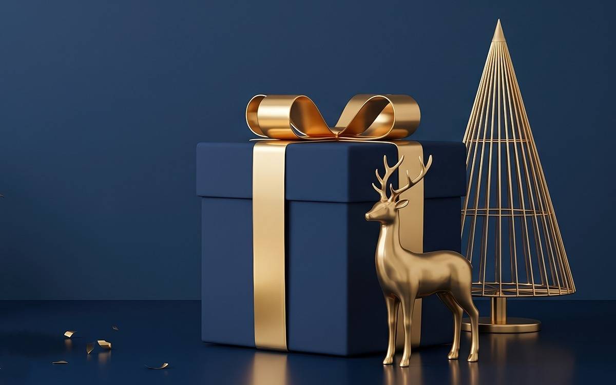 gold reindeer, wire tree and box with gold ribbon in dark blue setting