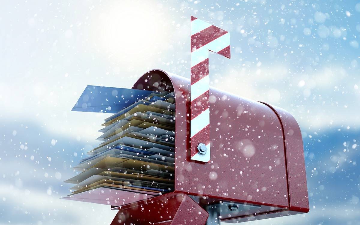 red mailbox stuffed with envelopes with snowy background
