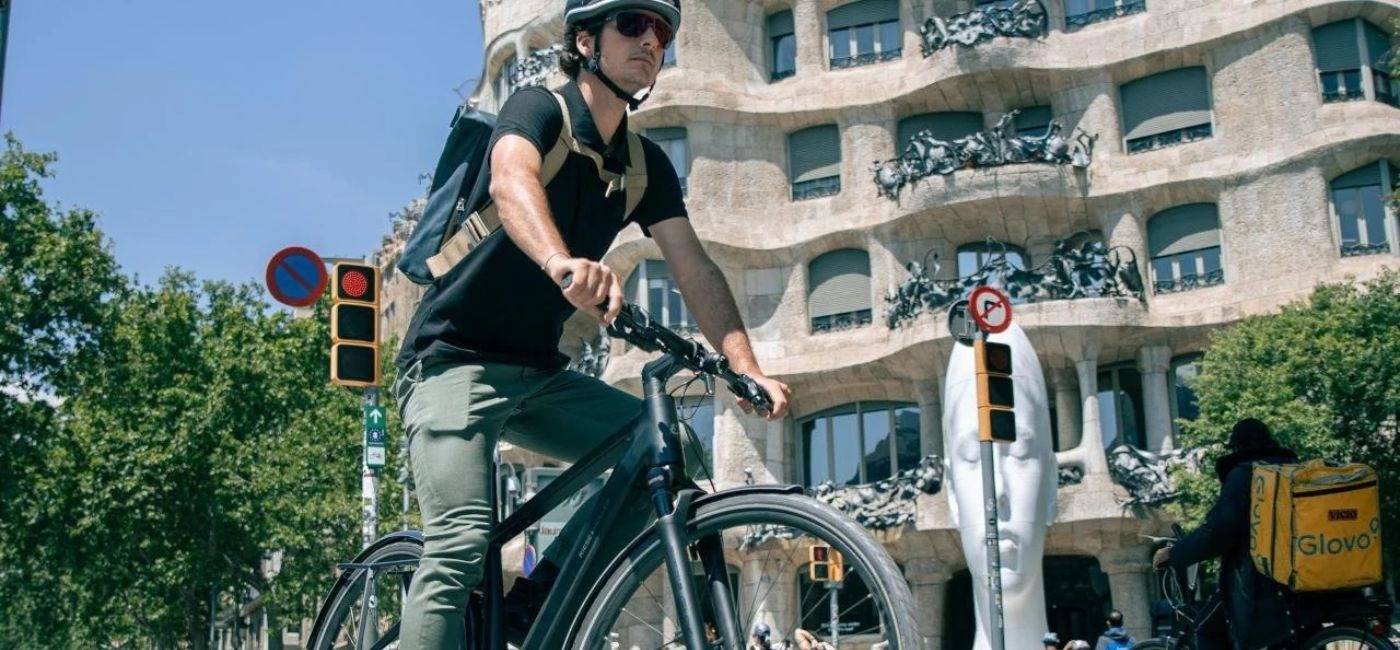 Ciclista con una bicicleta eléctrica urbana circulando por una calle de Barcelona