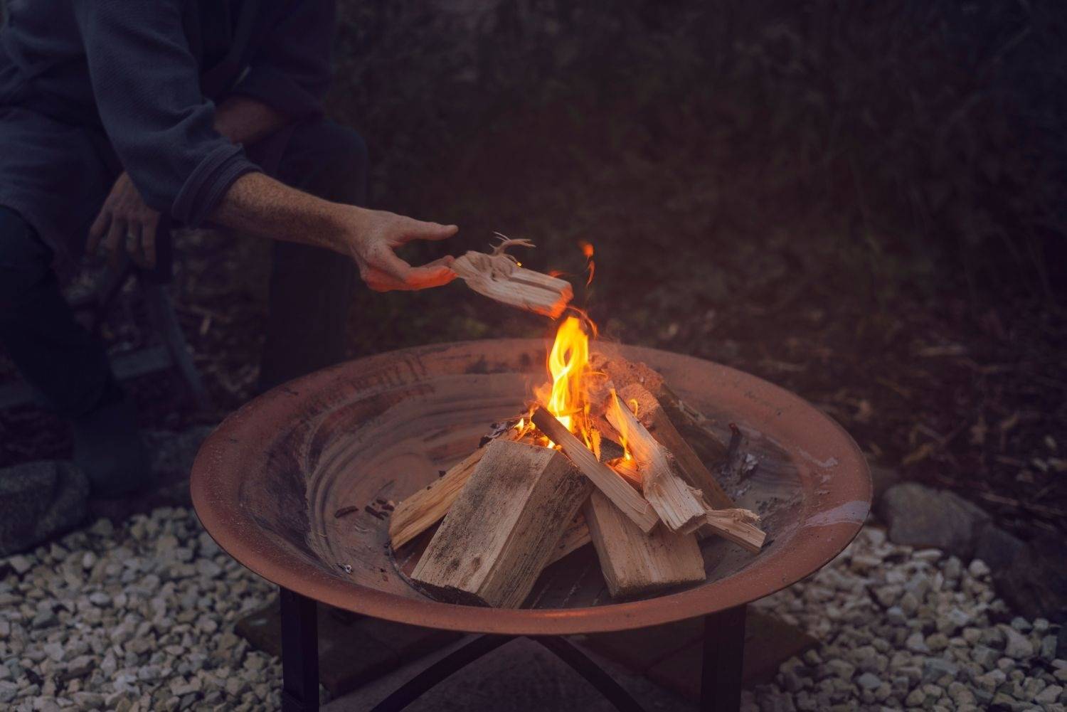 Teepee shaped arrangement of wood burning in a fire pit