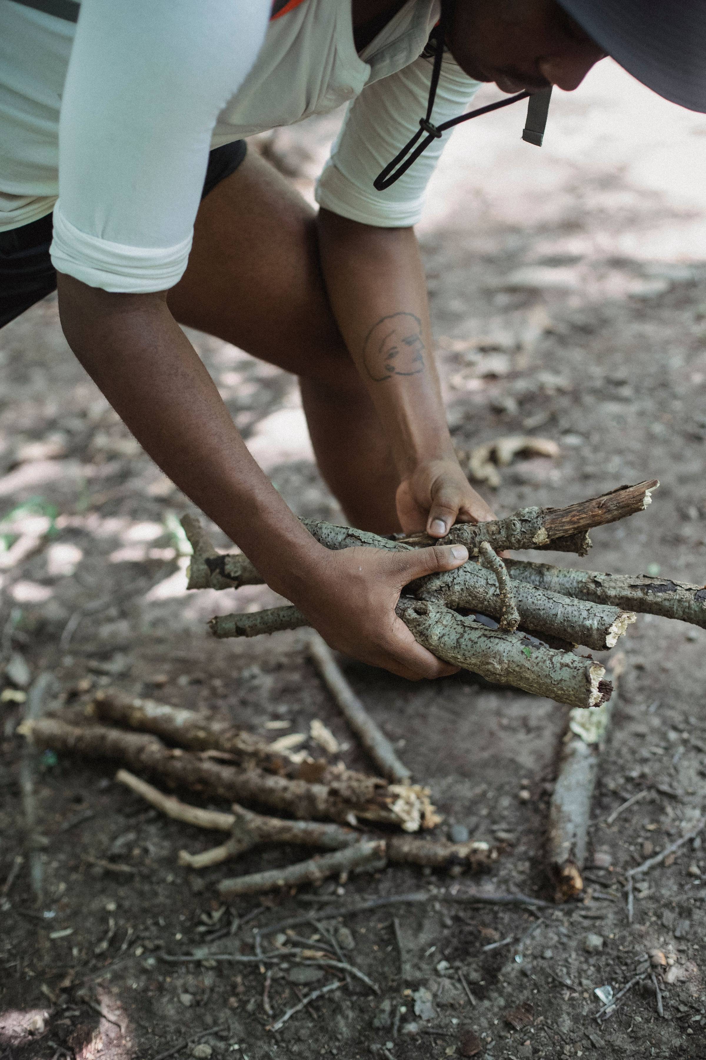 person gathering wood to build a campfire
