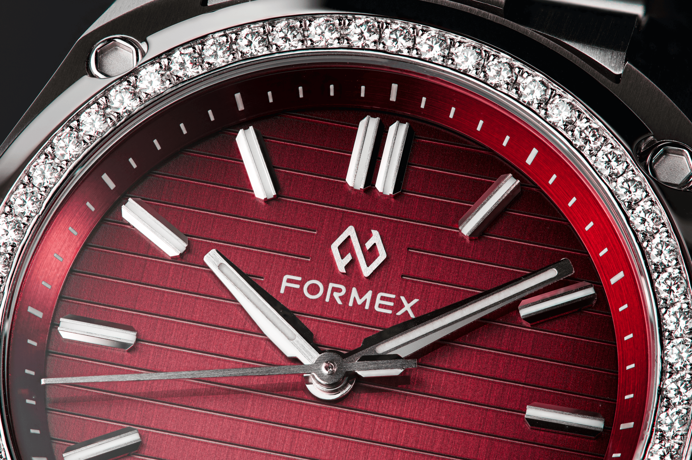 Close-up of a red Formex Essence with a diamond-set bezel